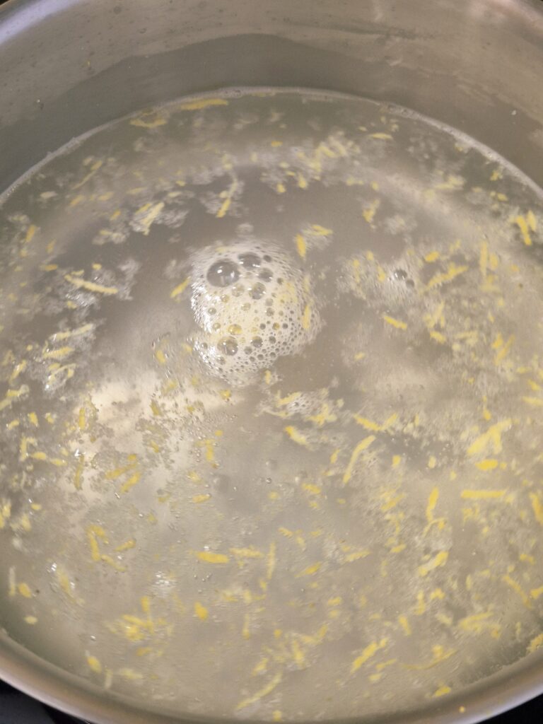 kochendes Zuckerwasser mit Zitrone für Löwenzahnsirup